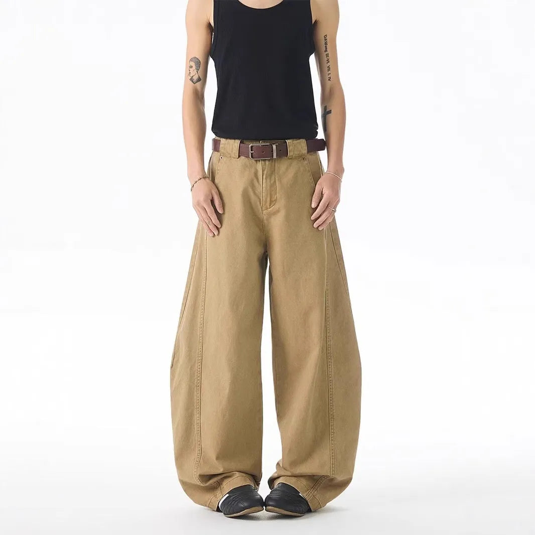 Brown loose fit straight leg men's jeans on a neutral background, showing button fly detail.
