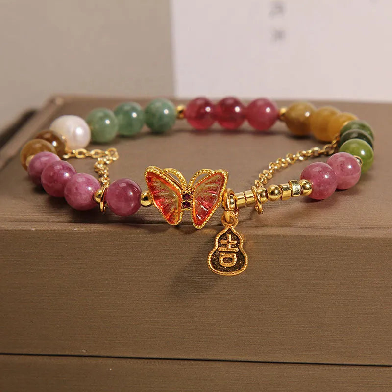 Close-up of a women's agate bracelet with a jade green tourmaline butterfly gourd bead.