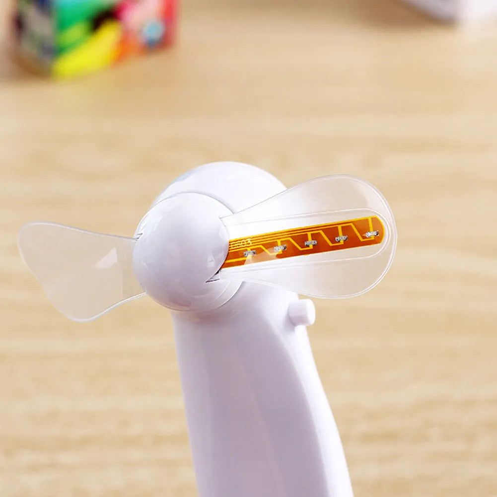 White handheld mini fan displaying a flashing blue and red 'I love you' LED pattern.