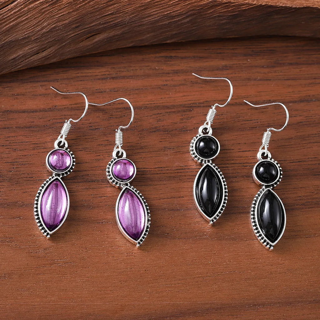 A pair of vintage-style geometric drop earrings in black and purple with a round element, bohemian jewellery.