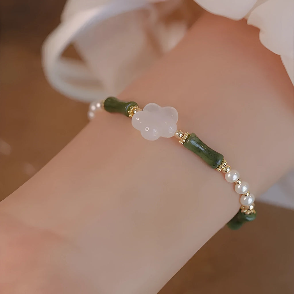 Handmade antique style bracelet with Hetian jade, copper shell pearls, and bamboo joint detail.