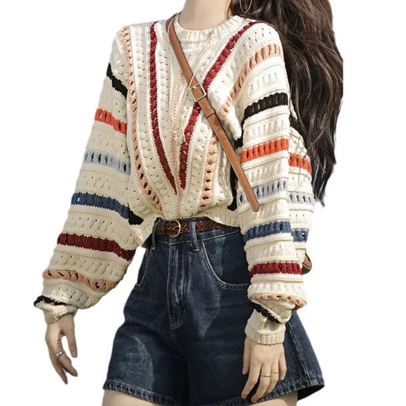 Colourful rainbow striped loose fit pullover sweater with batwing sleeves on a neutral background.