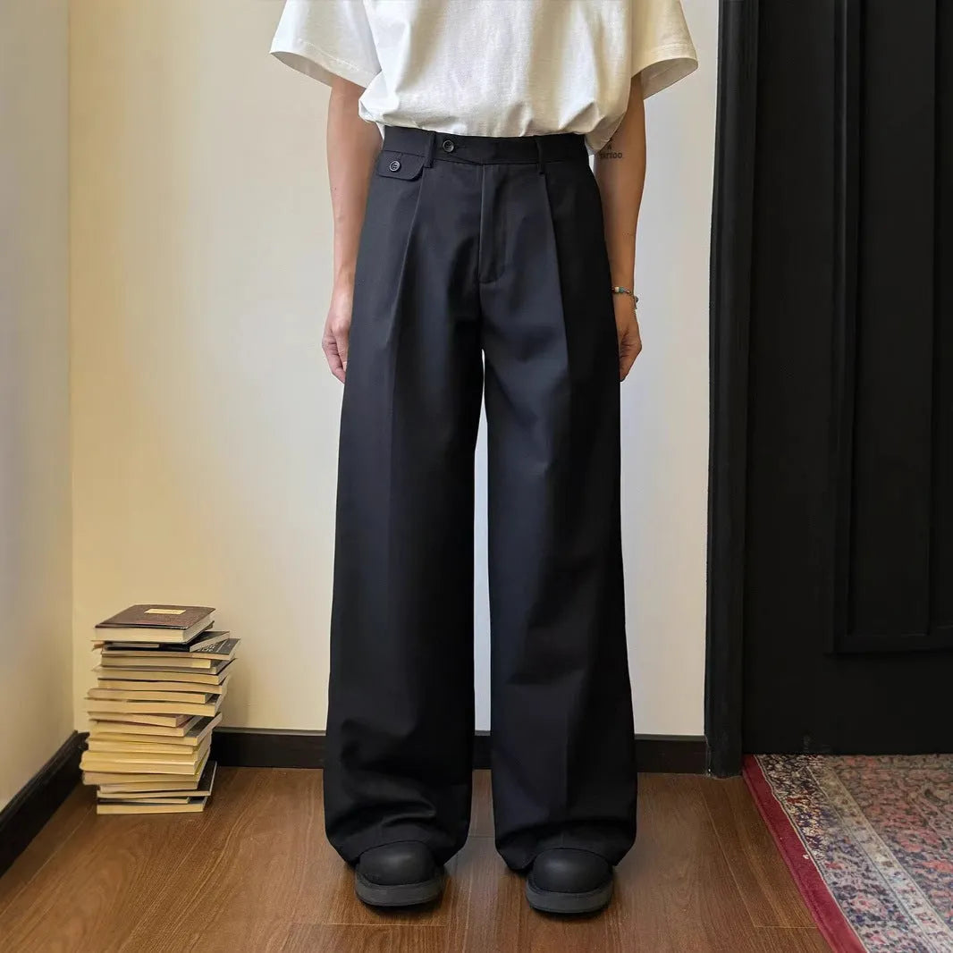 Man wearing solid colour straight-leg casual suit trousers with a loose wide-leg draping fit.