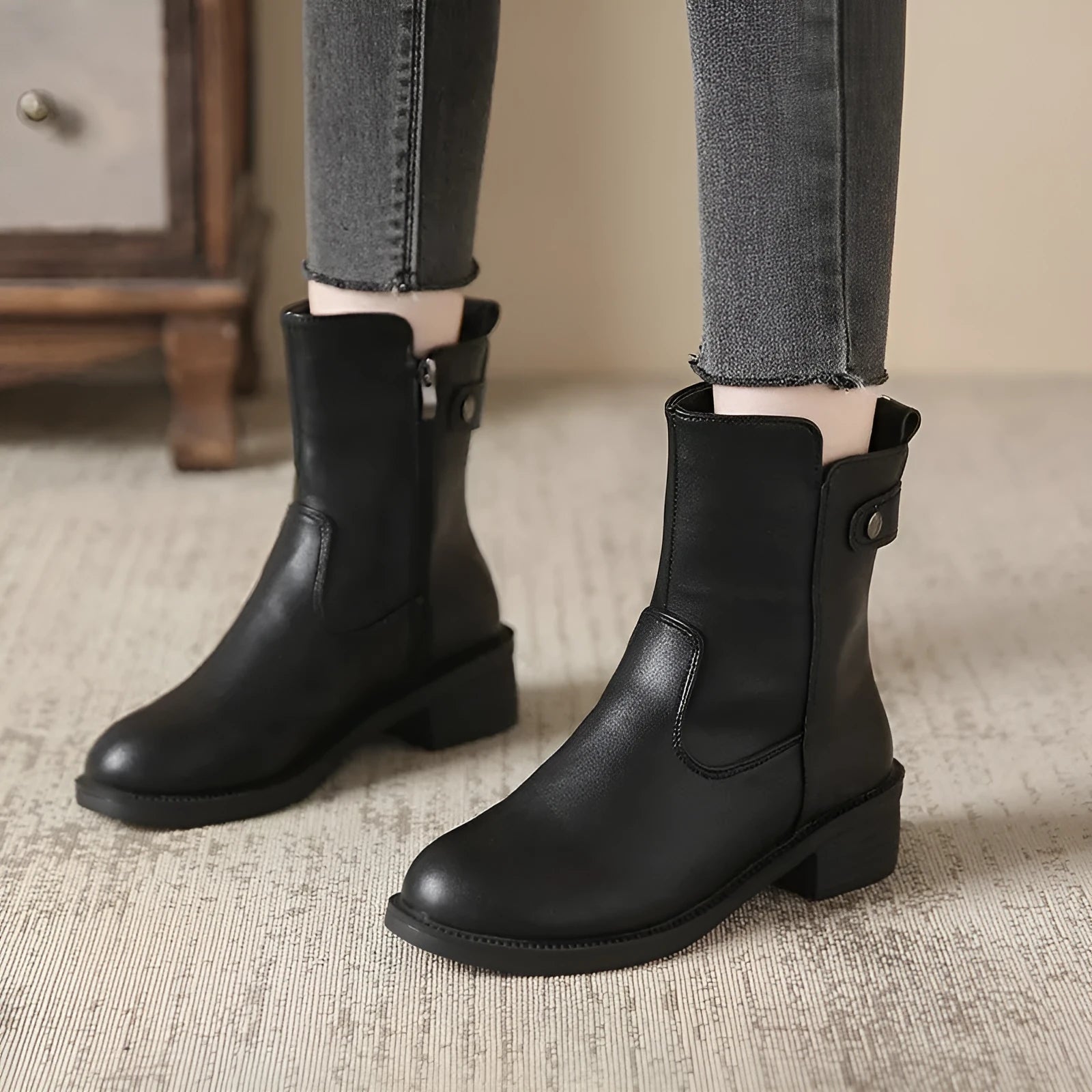 Black women's ankle boots with a side zip, round toe, and a low rubber sole.