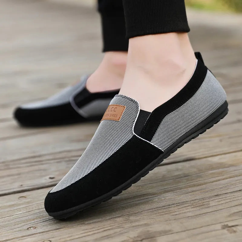 Men's grey and khaki canvas slip-on board shoes with round toe and rubber sole.