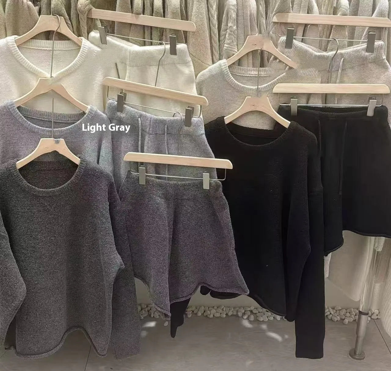 A woman's loose-fitting long sleeve knit sweater and matching wide-leg shorts set in a neutral colour.