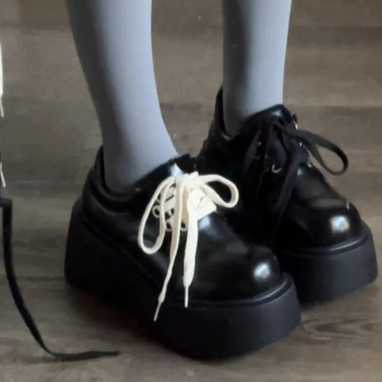 Black women's lace-up heels with a chunky rubber sole and a retro English muffin heel.