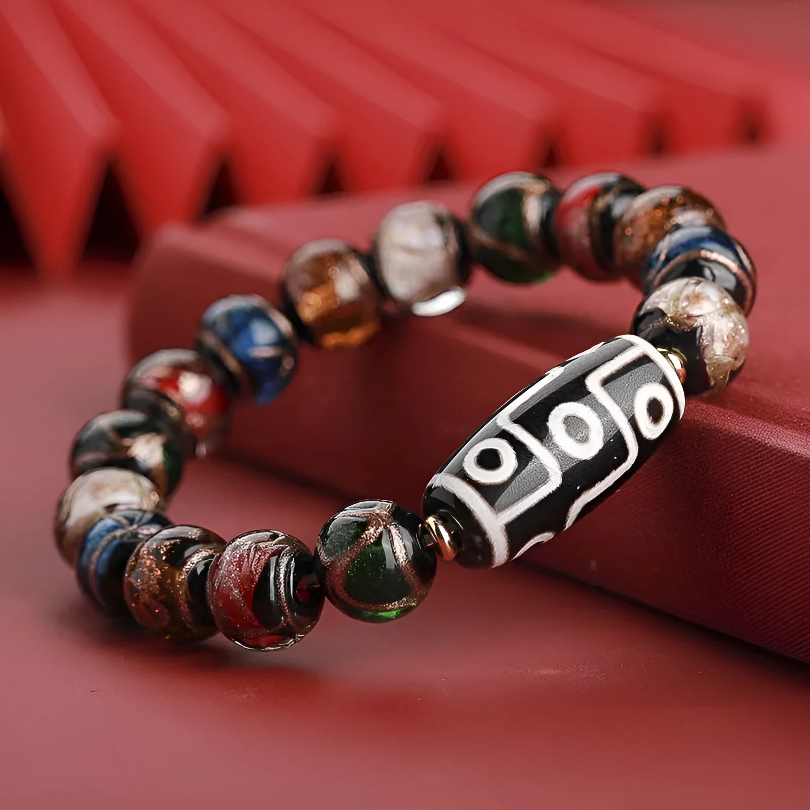 Chinese-style bracelet with coloured glaze beads showing snake and multi-treasure patterns.