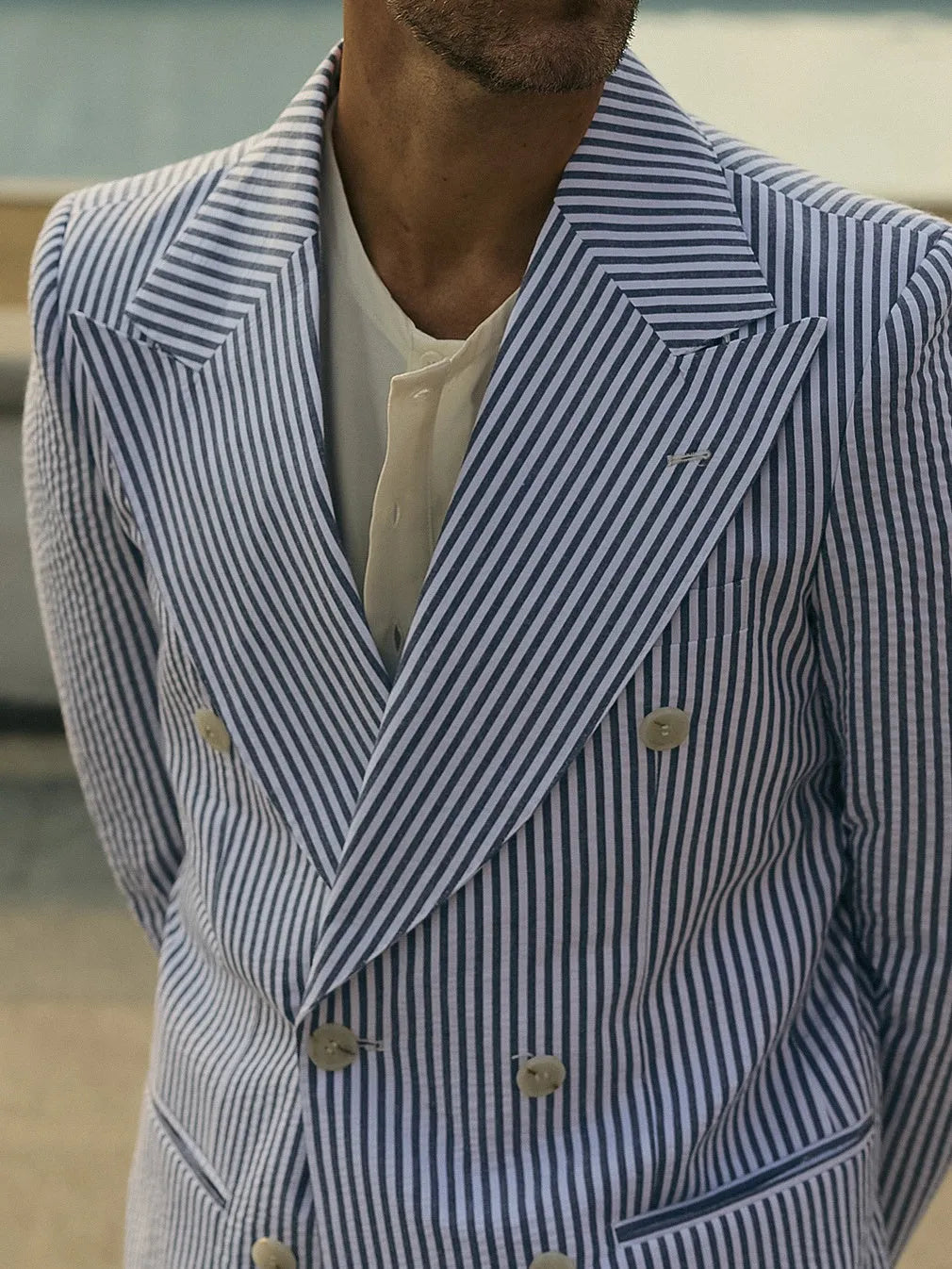 Blue and white striped polyester suit set with blazer and trousers on mannequin