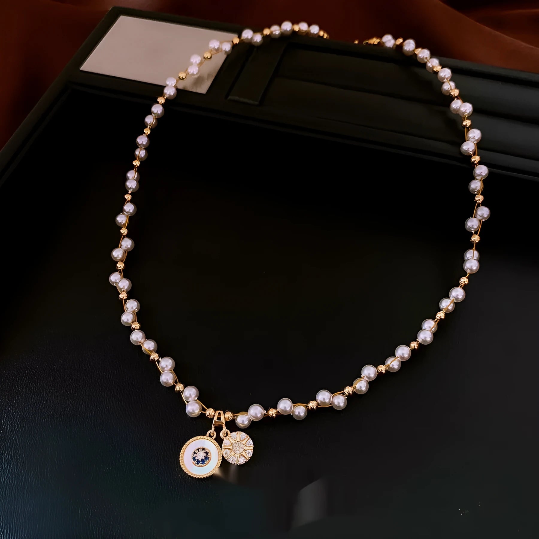 Gold electroplated necklace with round zircon-inlaid imitation pearl pendant on an adjustable clavicle chain.