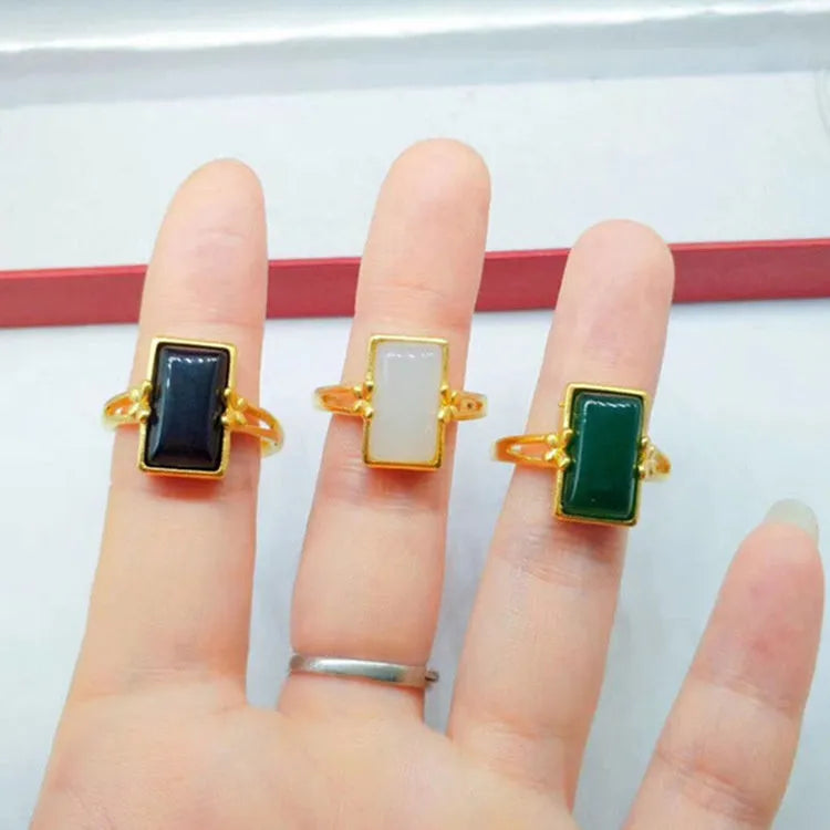 Adjustable gold plated brass ring with a national style design and a coloured inlaid gemstone.