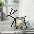 Wrought iron fawn candle holder with glass cup in gold electroplated finish on tabletop