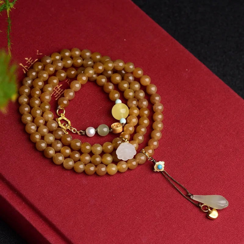 Green jade bracelet with round beads, pine elements, leaf designs, and sequin accents on wrist