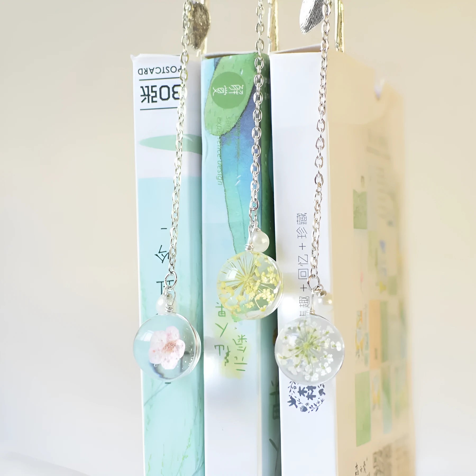 Close-up of a dried flower embedded in a rectangular alloy metal bookmark on an open book.