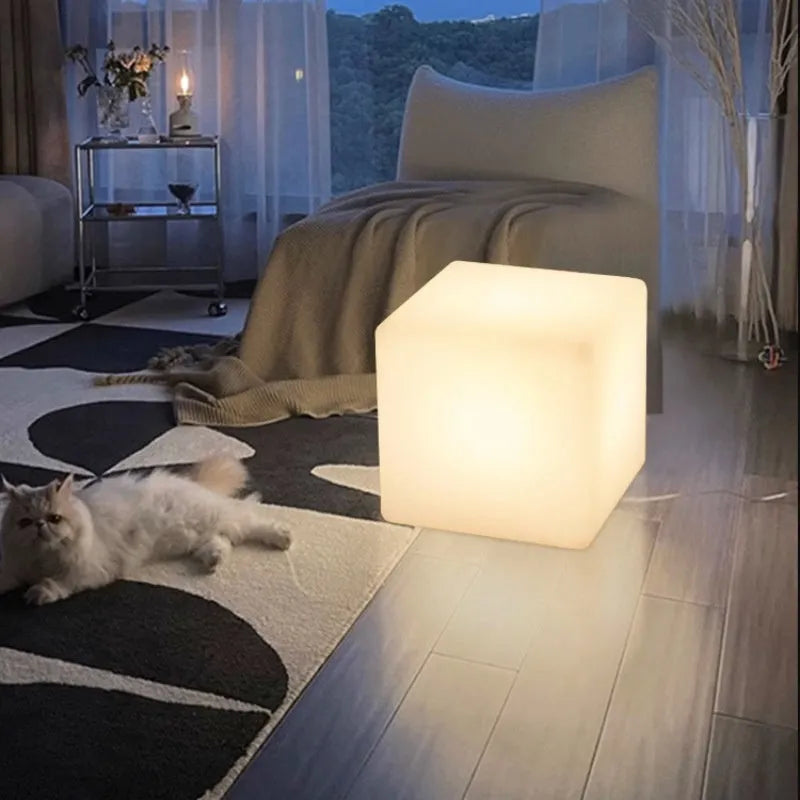 Modern square LED cube light stool in outdoor garden setting showing waterproof IP65 construction