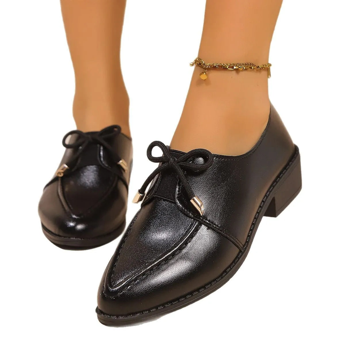 Women's casual leather shoes with a decorative bow on a pointed toe, showcasing a rubber sole.