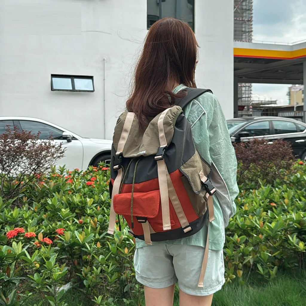 Orange and green outdoor backpack with multiple compartments and air pillow belt system