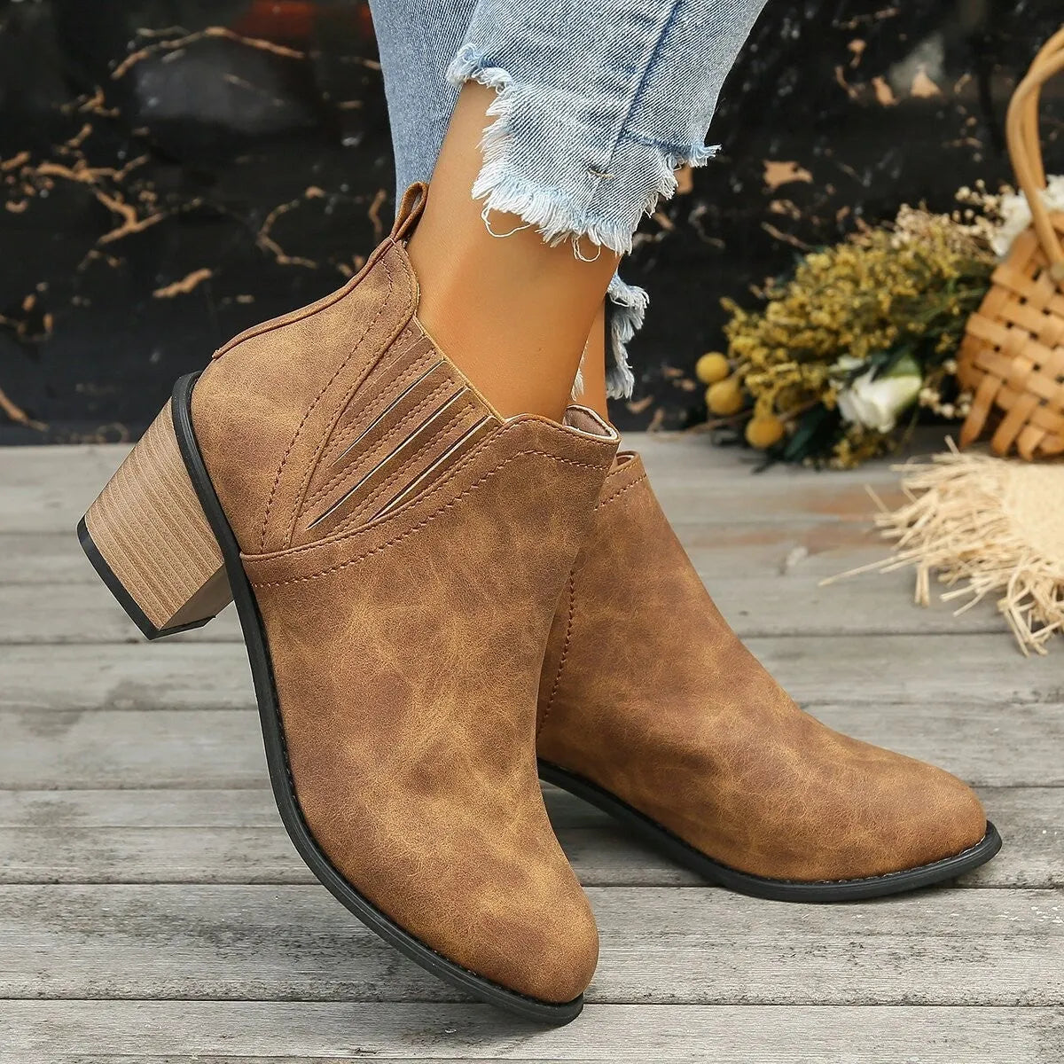 Black pointed toe women's ankle boots with a thick square low heel on a white background.