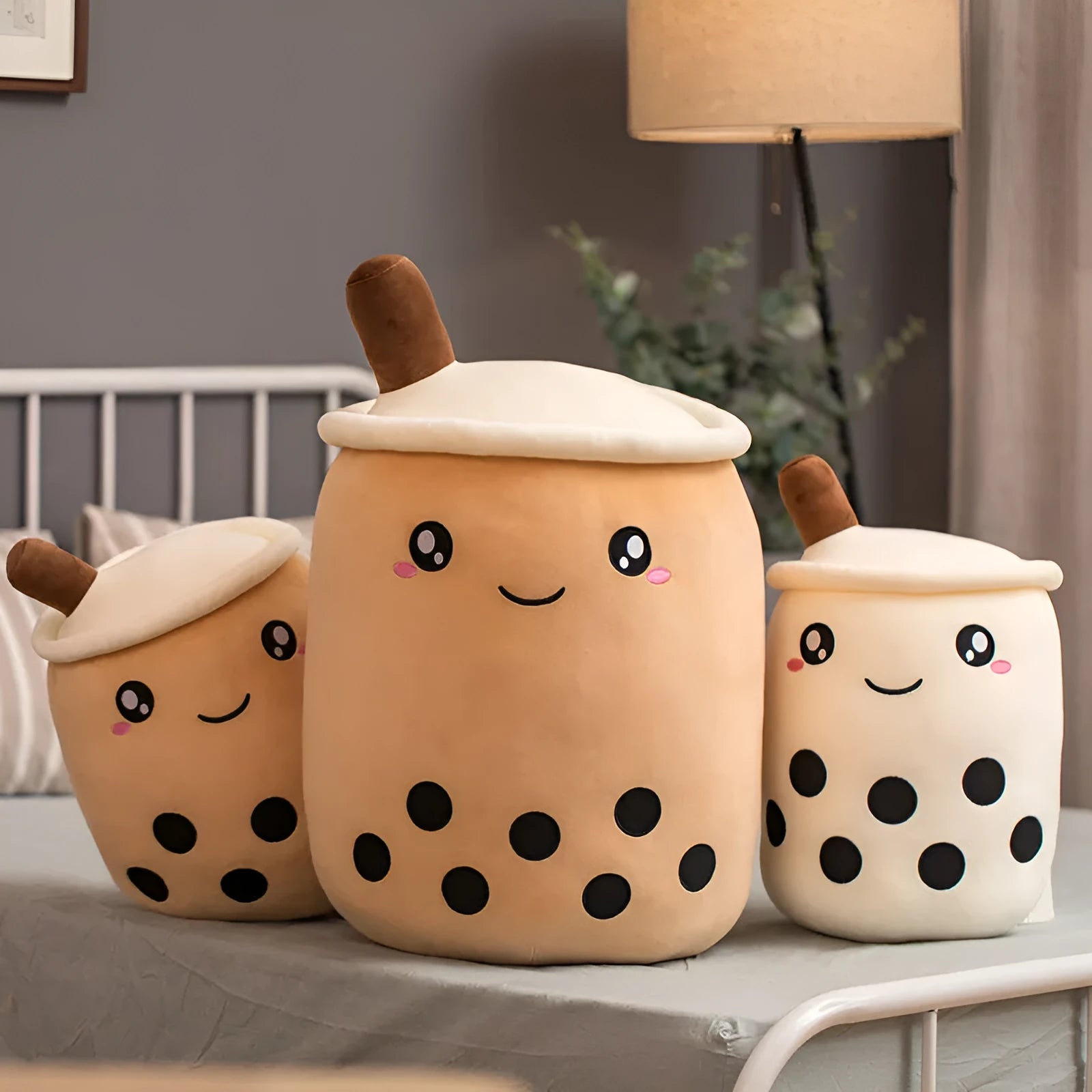 Brown boba milk tea plushie soft toy shaped like a cup with fruit, sitting as a cushion.