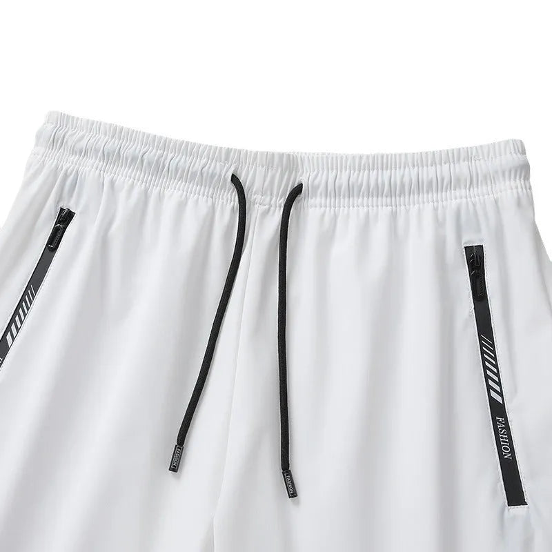 Man's black loose-fit quick-dry nylon sports shorts with elastic waistband on a plain background.