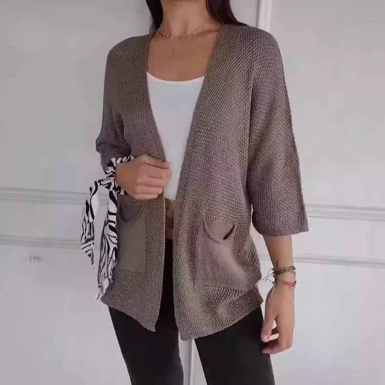 Women's longline waffle-textured cardigan coat in army green, showing pocket detail and nine-quarter sleeve length.