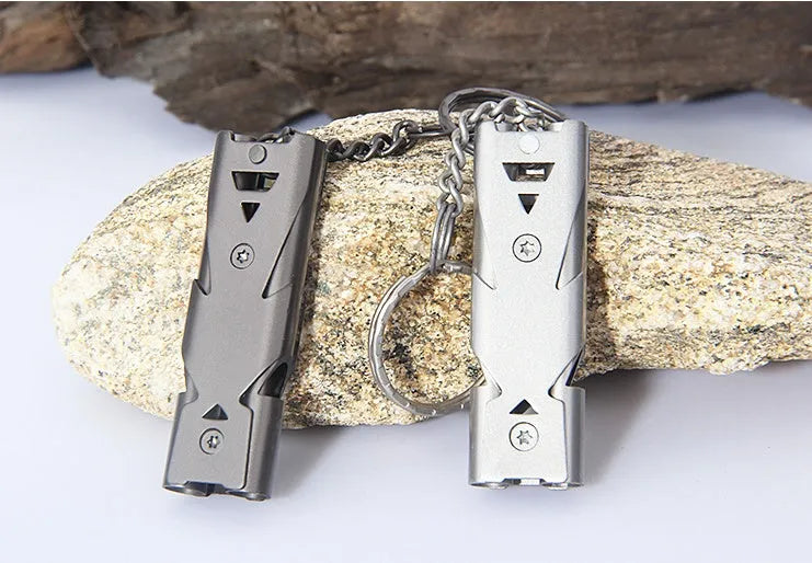 Compact keychain whistle in black and silver with keychain attachment for portable emergency signalling