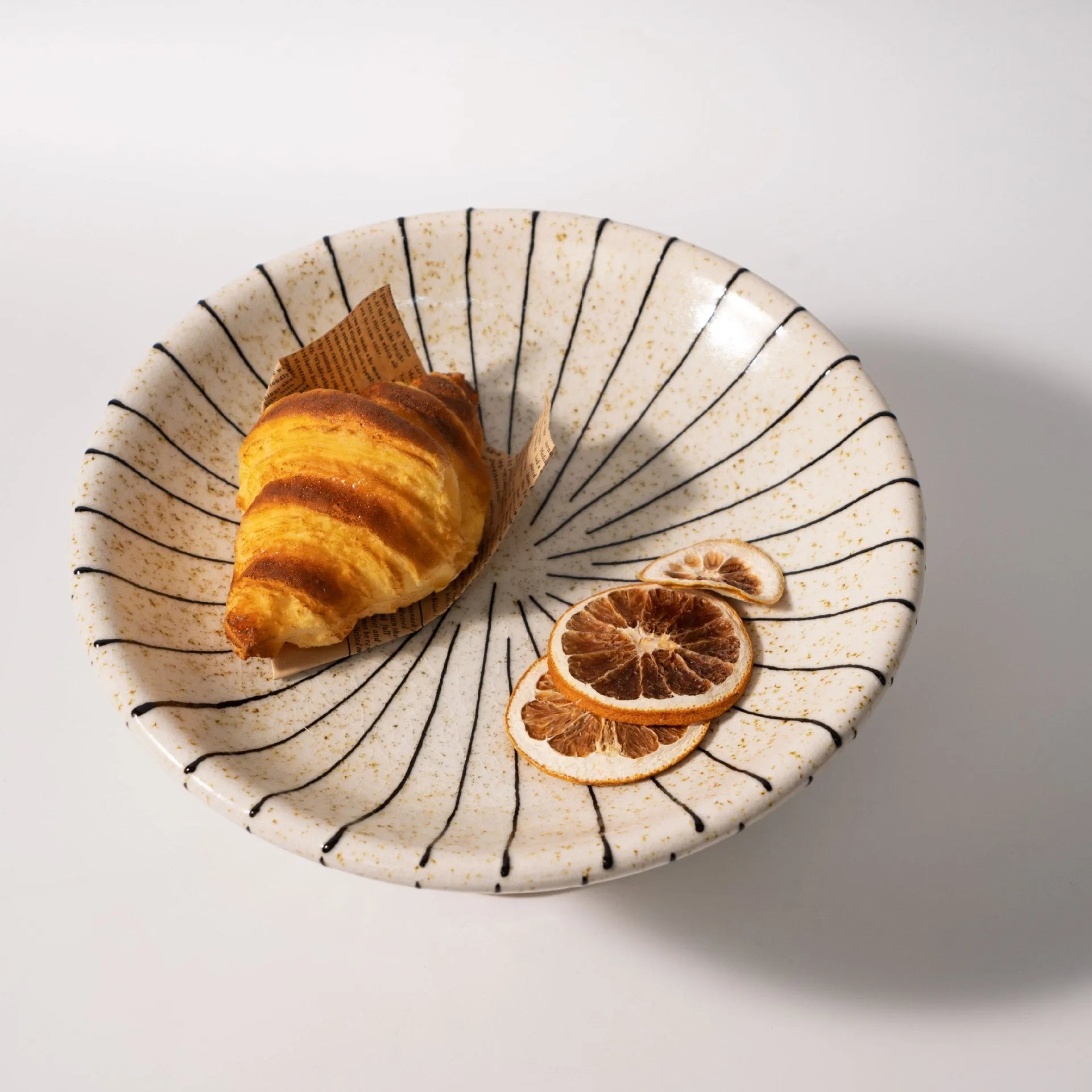 Black and white striped synthetic resin fruit dessert plate on a table