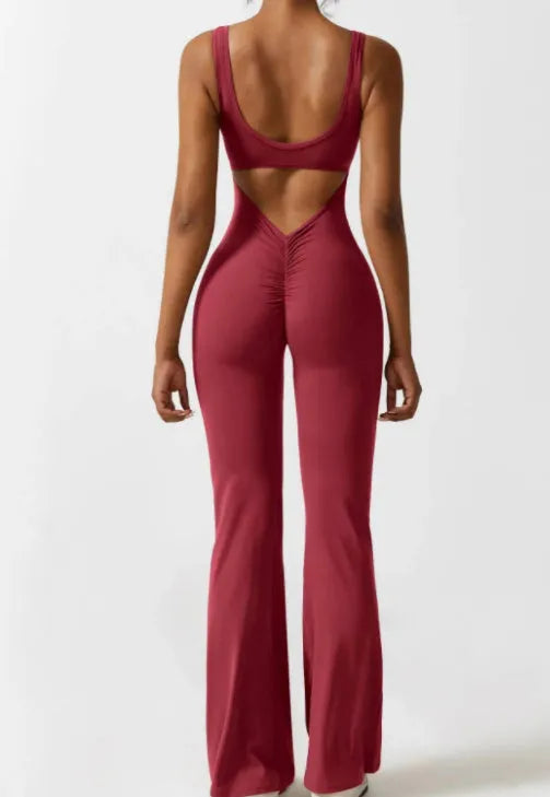 Black seamless women's yoga bodysuit jumpsuit with built-in chest pad, shown on model.