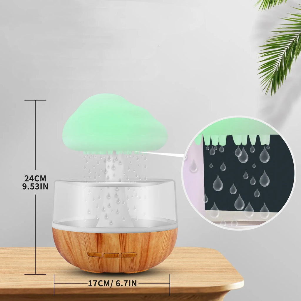 White cloud-shaped humidifier with multi-colour night light and essential oil diffuser on a table.