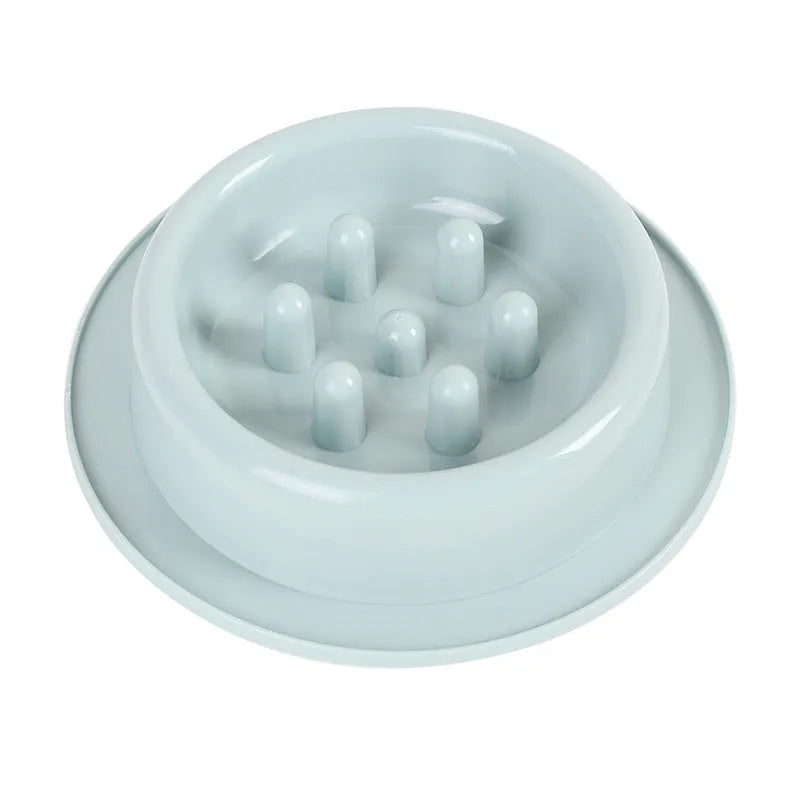 Blue pet slow feeder bowl with raised obstacles on a kitchen floor.