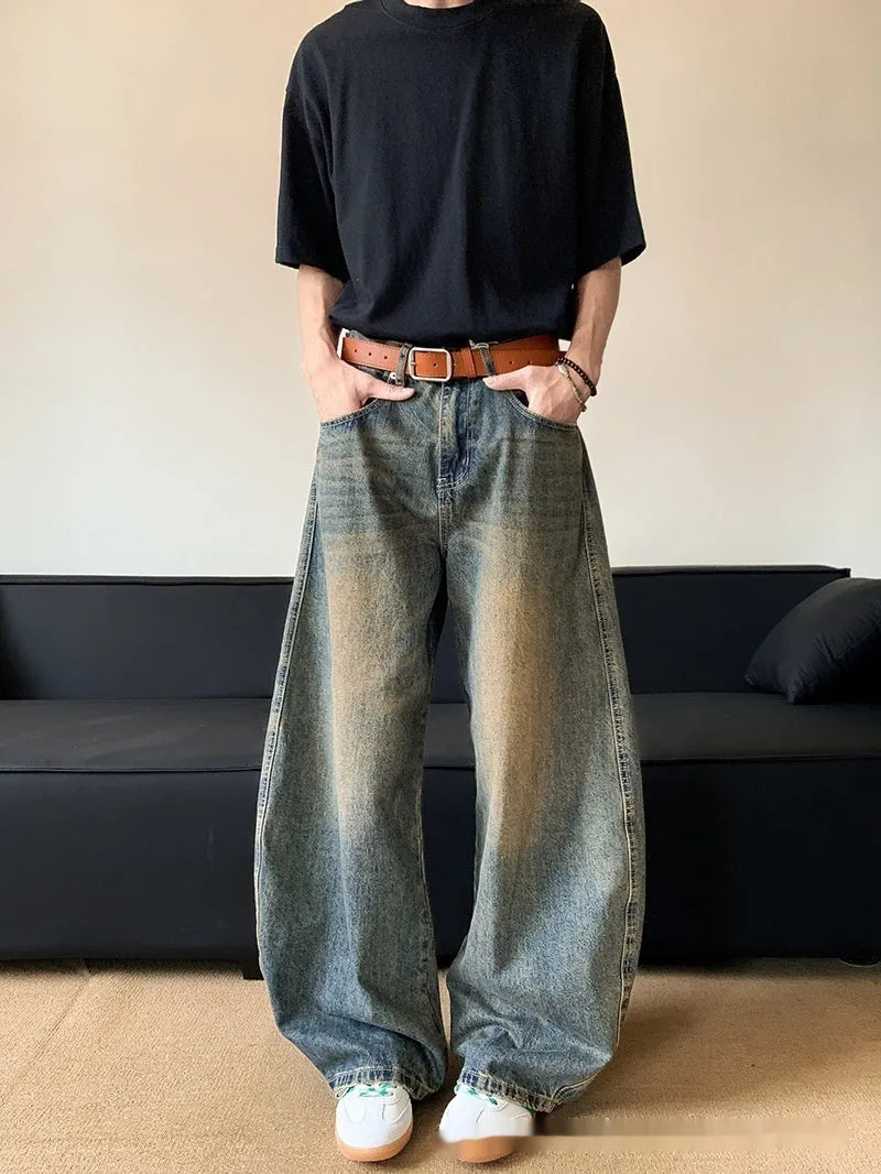 Men's retro blue distressed denim jeans with slim fit wide leg design showing machete wash detailing