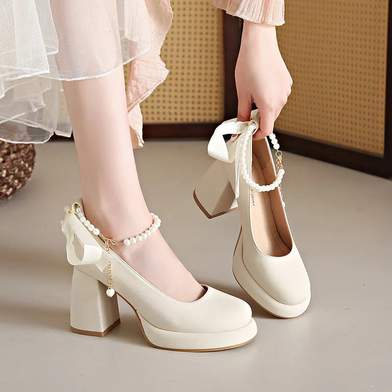 Women's beige Mary Jane shoes with a chunky heel and an adjustable ankle strap buckle.