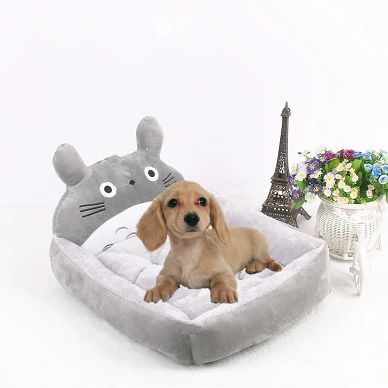 Blue sofa-style washable pet bed for a small dog on a wooden floor