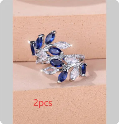 Adjustable copper leaf design ring with sparkling zircon stones on a model's finger.