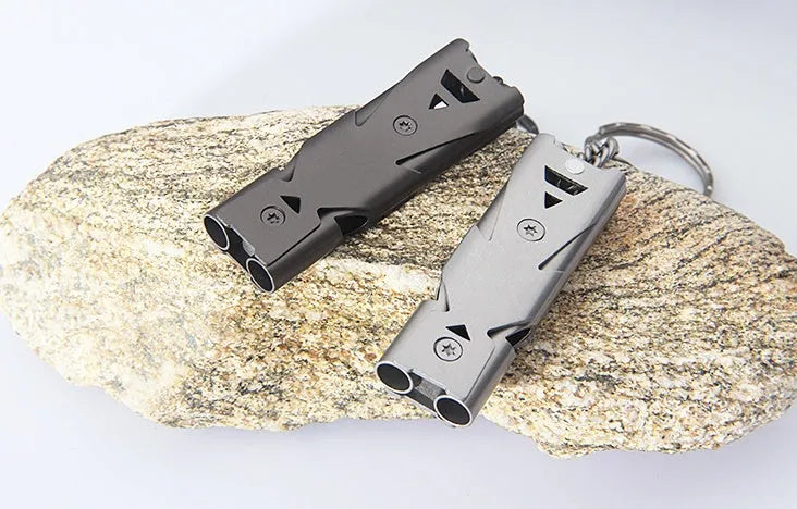 Compact keychain whistle in black and silver with keychain attachment for portable emergency signalling