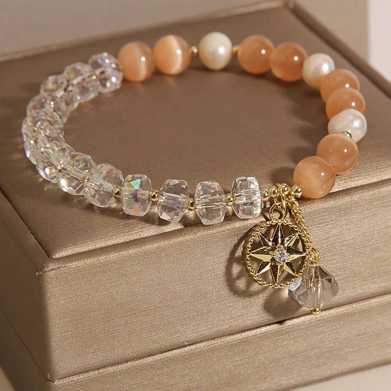 Women's gold-plated bracelet with an eight-pointed star design and a central inlaid orange opal crystal.