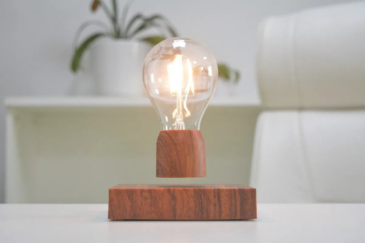 Magnetic levitation floating LED light bulb above an imitation wood base.