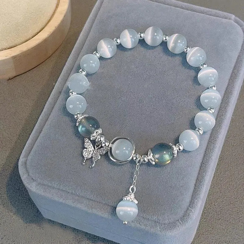 Women's opal cat's eye stone bracelet with diamond-shaped beads on wrist.