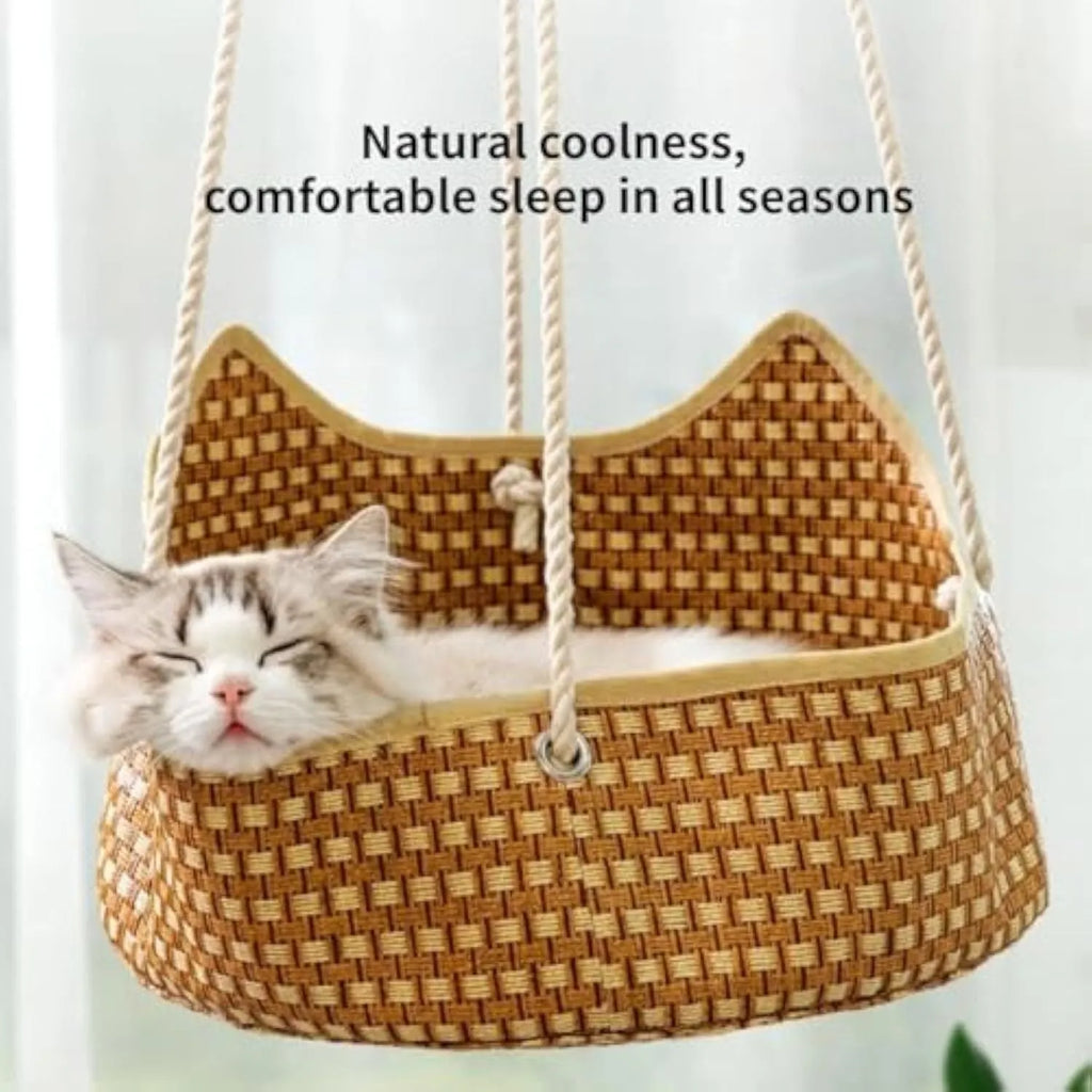 Green rattan cat hammock with metal hooks hanging on a white cage.
