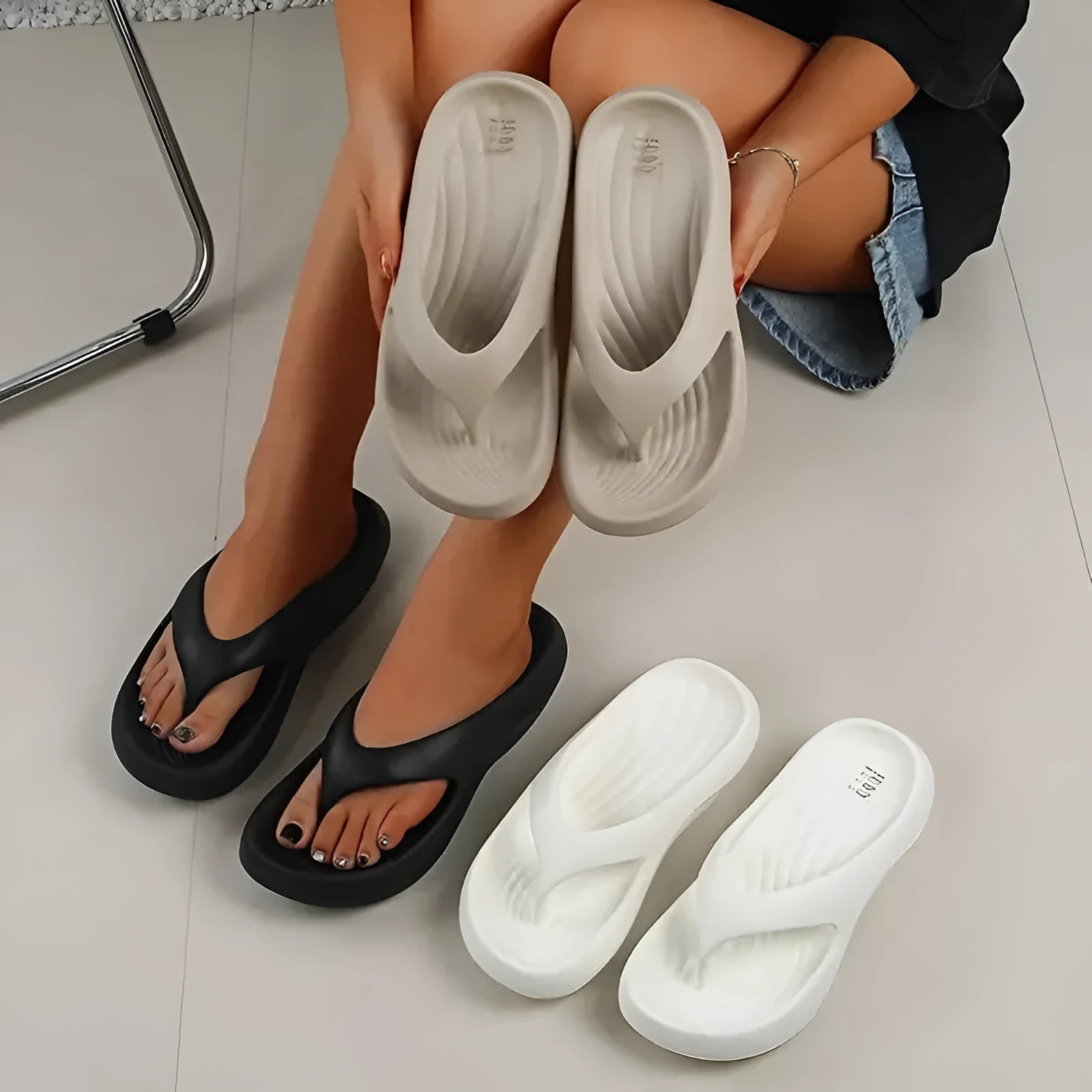 Black women's flip-flops with thick sole and textured non-slip tread.