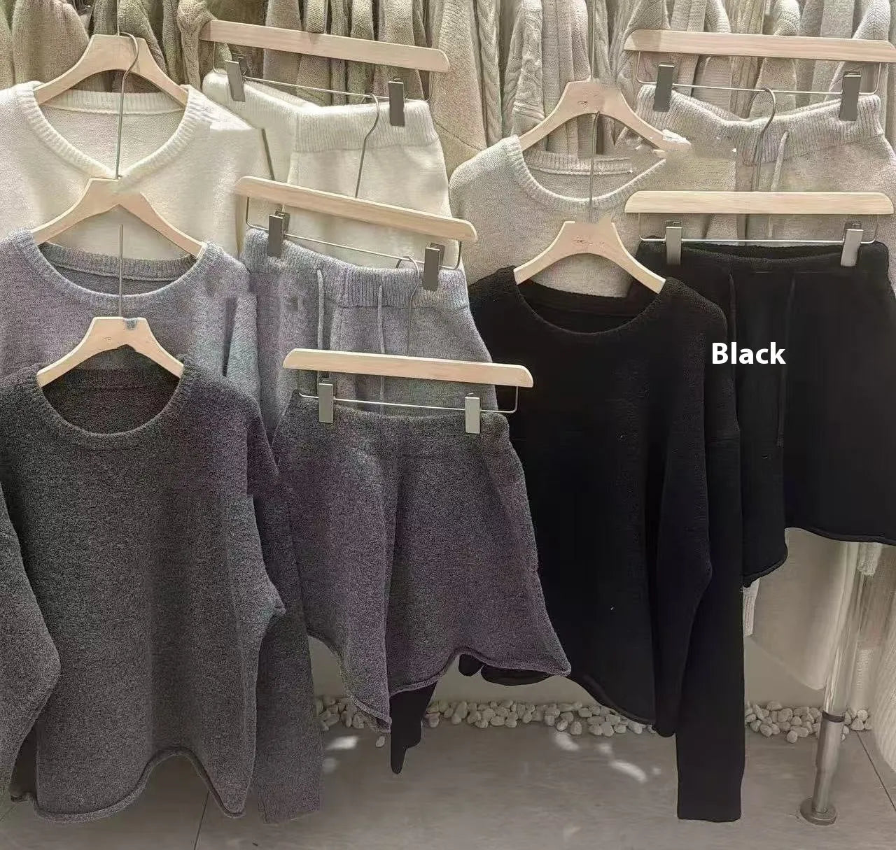 A woman's loose-fitting long sleeve knit sweater and matching wide-leg shorts set in a neutral colour.