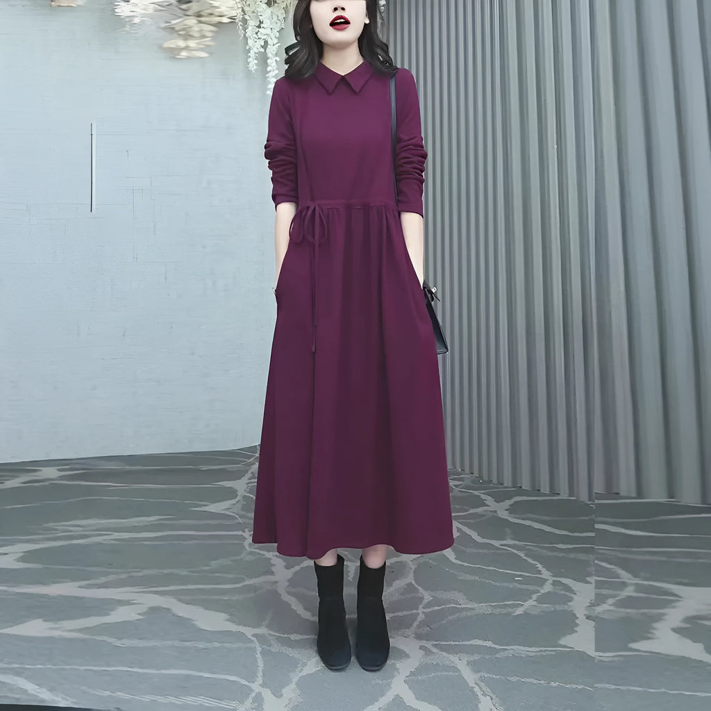 A purplish red long sleeve plus size dress for women, shown with extra-long sleeves and a long skirt.