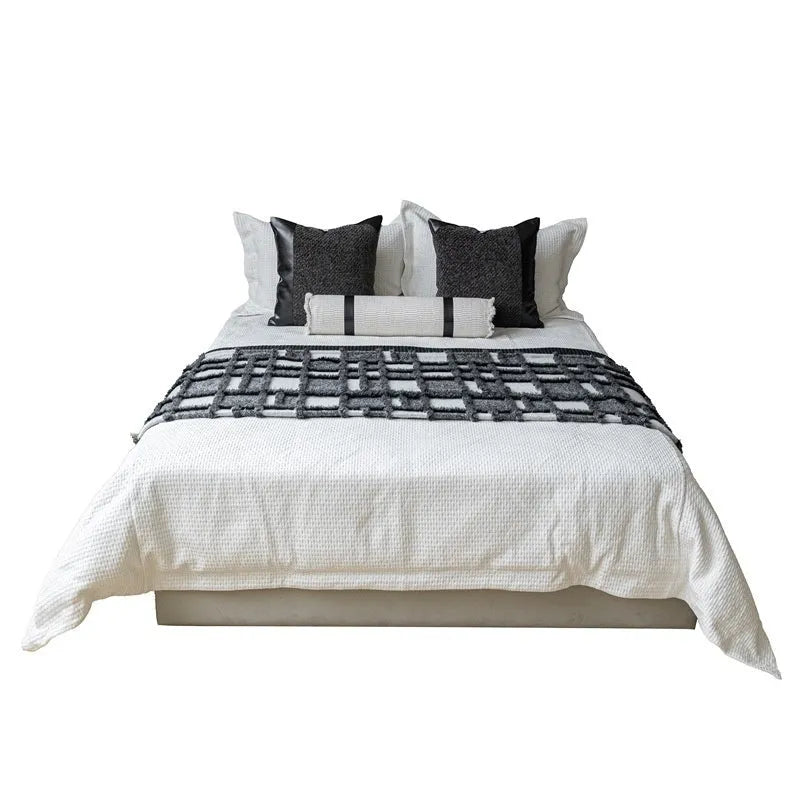 Modern grey and white plaid bed runner nap blanket set with pillow on a bed.