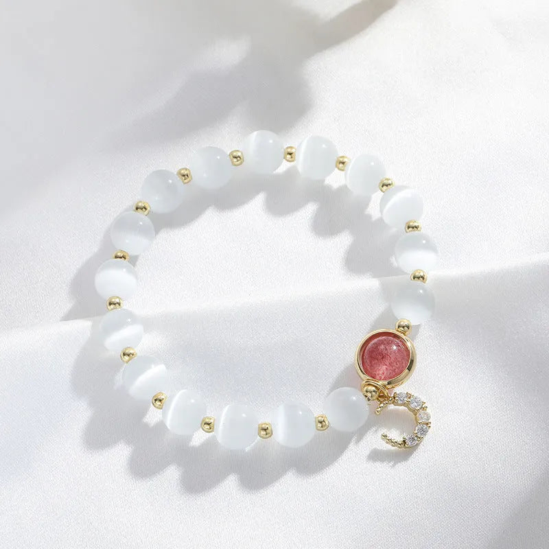 Women's opal cat's eye stone bracelet with diamond-shaped beads on wrist.