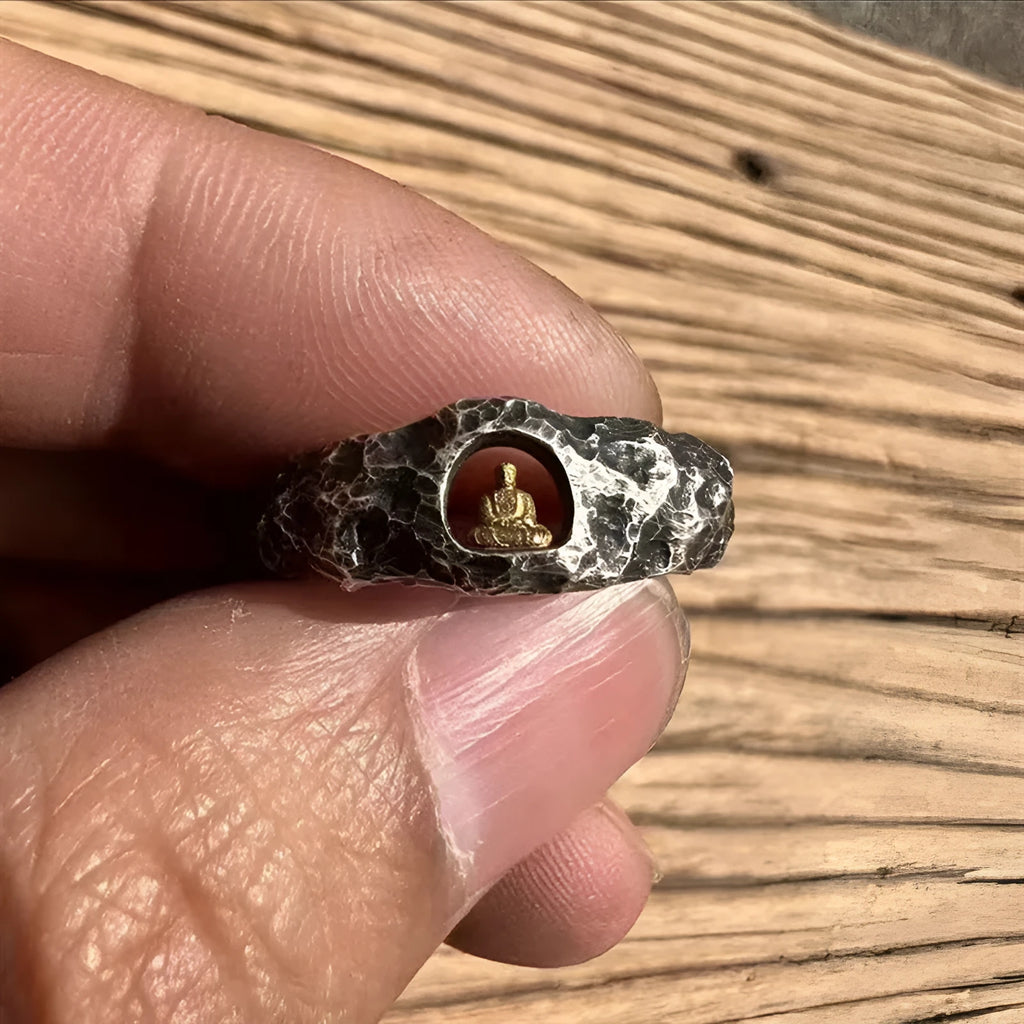 Close-up of a hand-forged copper Buddha ring with a grotto rock texture.