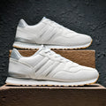 Men's black casual running shoes with a white carved wing pattern on the leather upper.