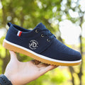 Men's black canvas casual work shoes with a non-slip sole and leather toe cap on a white background.