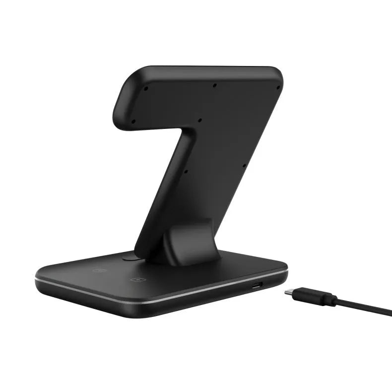 White three-in-one wireless charging stand for phone, watch, and headset on a desk.