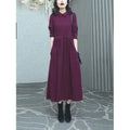 A purplish red long sleeve plus size dress for women, shown with extra-long sleeves and a long skirt.