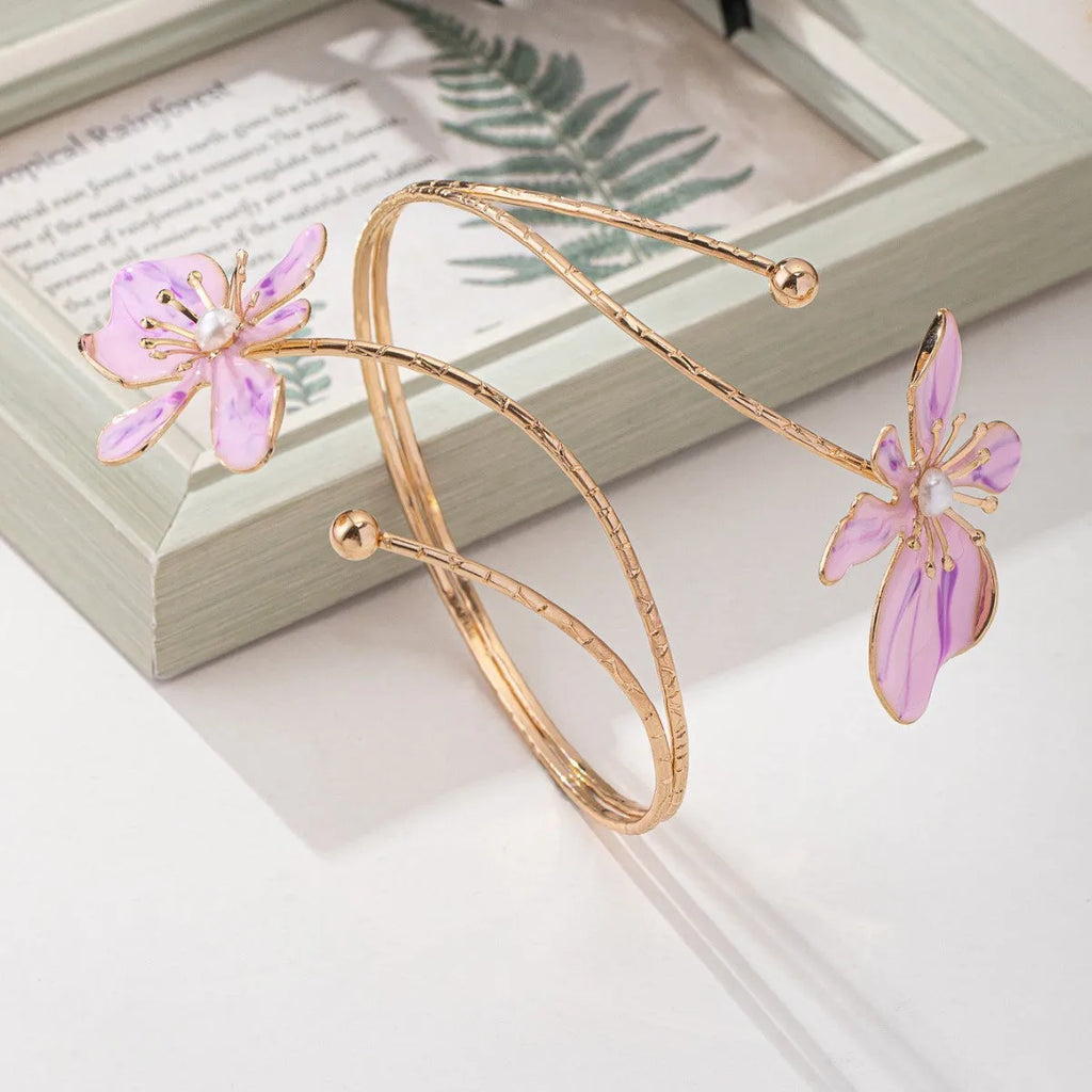 Close-up of a personalised pink alloy armband with a hollow line pattern.